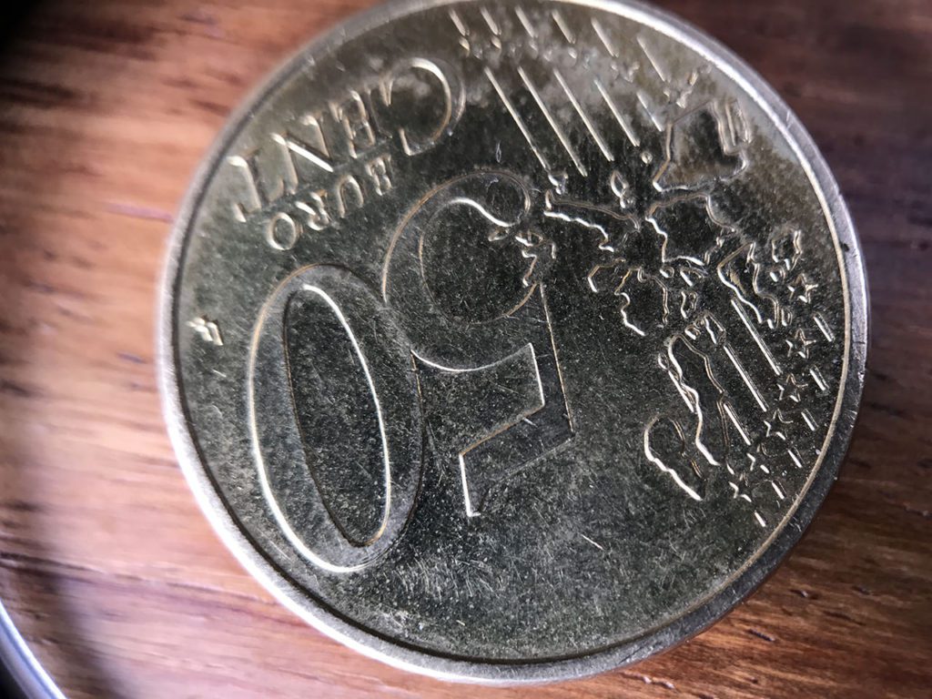 Bei diesem Foto einer 50 Cent Münze sieht man deutlich den Rand, der durch die Hülse des Objektivs entsteht. Ich lasse sie aus diesem Grund lieber weg…