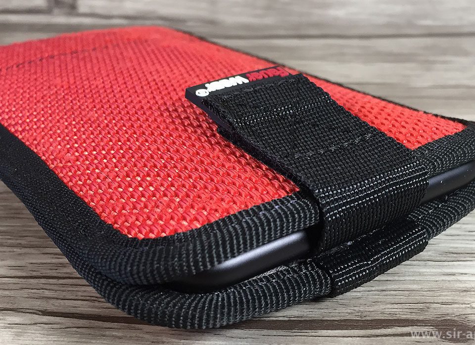 The iPhone is held securely inside by the Velcro fastener on the strap.