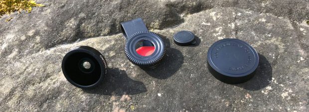 Le singole parti di un obiettivo per smartphone inLine inclusi clip e coperchio antipolvere.