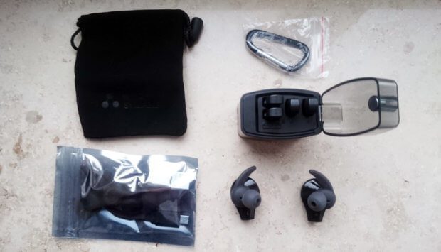 The contents of the shell: transport bag, bag with cable, earplugs and brackets, a carabiner and of course the Syllable D9X headphones with batteries and charging cradle.