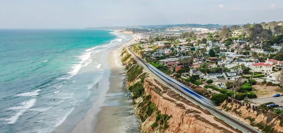 Hier sieht man eine Fotoaufnahme, die der Youtuber Flypath mit der Mavic Pro und einem ND1000 Filter von Freewell gemacht hat. Trotz 10 Blendenstufen mehr, hat er bei Tageslicht nur 1/8s Belichtungszeit geschafft. Nicht genug für richtig weiche Brandung oder spannende Wolken, aber man sieht den verwaschenen Zug im Vordergrund. In der Dämmerung dürften damit spannendere Effekte zu schaffen sein (Quelle: Youtube Video)..