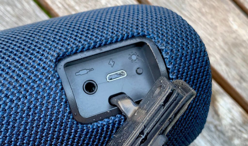 Głośnik Bluetooth spędził dobre 10 minut w oczku ogrodowym, ale gniazda w tylnej komorze są suche. Gumowa osłona oczywiście skutecznie chroni przed wnikaniem wody.