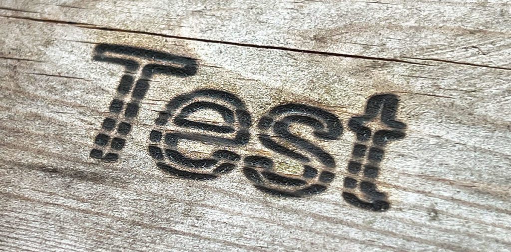 Das ist das Erste, das ich graviert habe – "Hallo Welt" wäre vielleicht kreativer gewesen, aber Test ging schneller. Die Unschärfe des Schriftzugs liegt vermutlich daran, dass ich den Laser nicht fokussiert hatte.