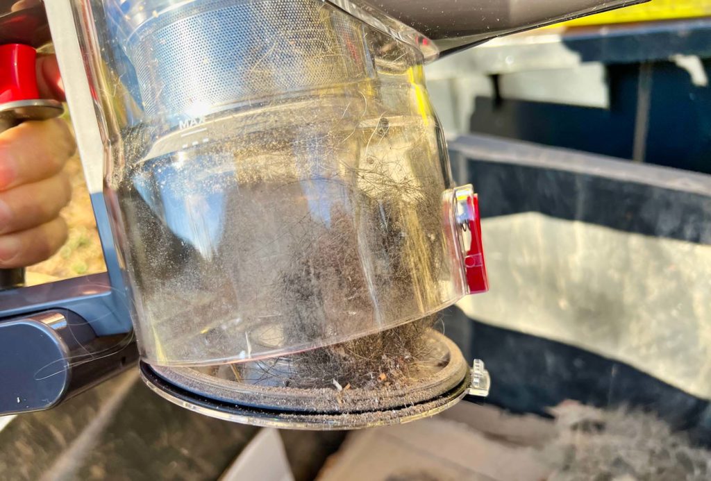 Puoi aprire il contenitore della polvere a destra del dispositivo di fissaggio rosso, quindi il dispositivo di fissaggio si apre e puoi svuotare la polvere e i 1000 peli di cane e gatto.