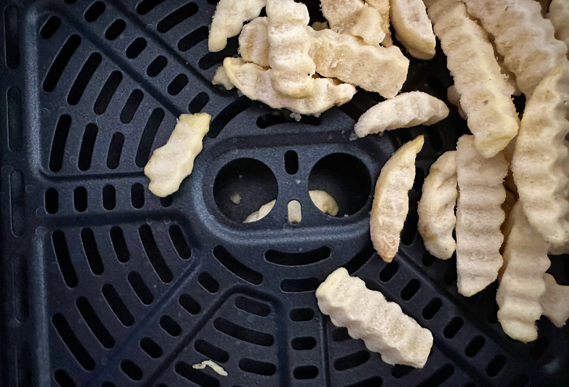 Das Knusperblech hat in der Mitte zwei Löcher, um es zu entnehmen. Leider fallen dort immer einige Pommes rein, die dann beim Entleeren nicht raus kommen.