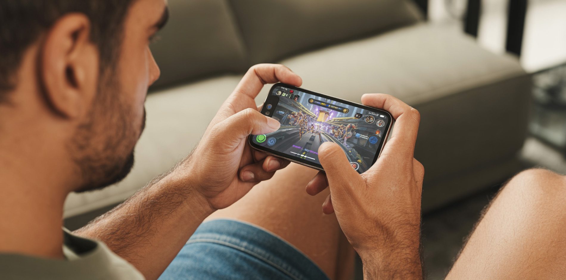 Mann spielt ein Browsergame auf seinem iPhone, Fokus auf dem Spiel, Hintergrund unscharf.