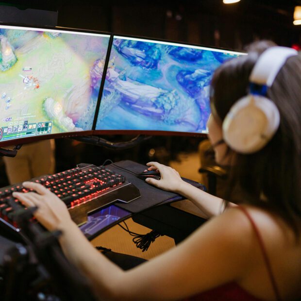 Gamerin sitzt an 3 Monitoren